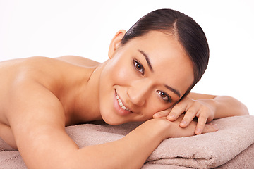 Image showing Smile, portrait and woman at spa for massage with skincare, grooming or body treatment in studio. Happy, health and face of Asian female person on table for relaxing routine by white background.