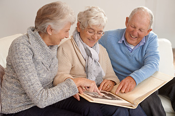 Image showing Elderly people, group and together with photo album, living room and pictures with memories, lounge and home. Seniors, smiling and happy in retirement in Canada, pointing and bonding with nostalgia