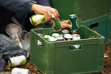 Image showing Liquor, person and hands with drinks, beer and beverage product for drinking a can in party. Closeup, outdoor or tin container for liquid, alcohol or crate in case package on ground or floor by trash