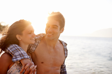 Image showing Beach, happy and couple with vacation, sunshine and weekend break for honeymoon, travel and adventure. Hug, seaside and embrace with man, smile and woman with holiday and love with journey and summer