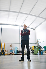 Image showing Man, logistics and portrait with arms crossed in factory for confidence, pride and industry. Senior manager, merchandise and in warehouse for inspection, shipping and distribution in low angle