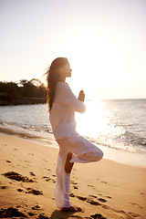 Image showing Meditation, prayer and balance with woman on beach at sunset, mindfulness and zen with fresh air for calm outdoor. Ocean, breeze and travel with yoga for health, peace of mind and holistic healing