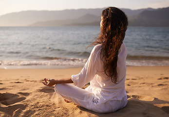 Image showing Back view, woman and meditation on beach with lotus pose, mindfulness and zen with fresh air for calm outdoor. Ocean, breeze and travel with yoga for health, peace of mind and holistic healing