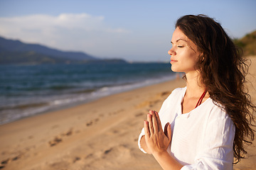 Image showing Prayer hands, woman and meditation on beach with mindfulness, eyes closed and zen with fresh air for calm outdoor. Ocean, breeze and travel with yoga for health, peace of mind and holistic healing