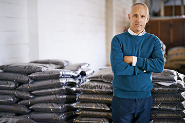 Image showing Coffee, warehouse and portrait of man with bags for distribution, quality control and confident logistics. Export, manufacturing and proud entrepreneur with beans at factory for sustainable business