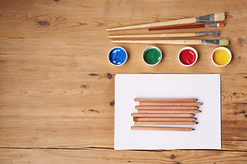 Image showing Table, paint and brush with stationery for school project or assignment on creative art, design and drawing. Wooden desk, supplies and pencil for writing exams or test with blank page for ideas.