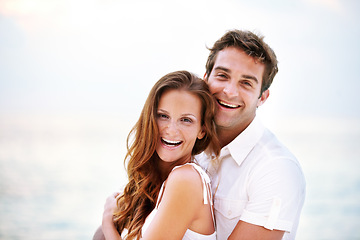 Image showing Happy couple, portrait and holiday by ocean for love and travel on honeymoon adventure in sun. Man, woman and smile face for bonding in marriage, touch and together on beach vacation in cape town