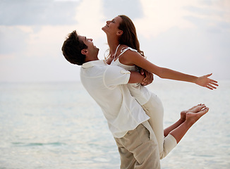 Image showing Couple, celebrate and hug on beach in summer for travel, vacation and holiday in spain together. Man, woman and embrace in paradise by ocean for love, support and romance with freedom and care