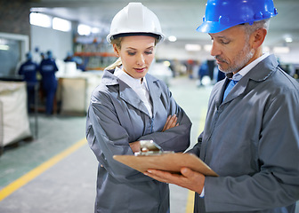 Image showing Man, woman and discussion with clipboard in factory for quality inspection or safety checks and process monitoring. Team, communication and board for manufacturing information in printing warehouse.