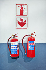 Image showing Wall, fire extinguisher and sign for safety, emergency or protection in interior of room. Metal, equipment and tools for security with chemical in steel container for danger prevention on background