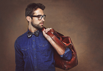 Image showing Travel, bag and man with fashion thinking of vacation in studio, background and mockup for business. Formal, style and luxury leather luggage for airport, journey to Italy and model in glasses