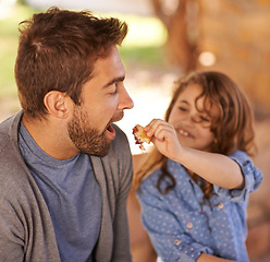 Image showing Happy father, food and girl feeding in morning on bench with family for breakfast, nutrition and happiness. Dad, child and meal outdoors for food, health and sharing with open mouth, smile and joy.