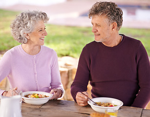 Image showing Outdoor, senior and couple with smile for breakfast, eating and happiness in backyard for romance. Partners, woman and man in marriage with food in nature of garden in home, fruit and nutrition