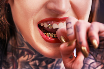 Image showing Woman, bite and hand with tattoo and nails for grill on tooth and ink design for creative and unique. Art on skin for bold and cool for statement and funky for trend, gold and pattern with red lips