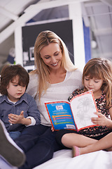 Image showing Reading, mother and children on sofa with book for bonding, teaching and learning together in home. Woman, son and daughter relax on couch with storytelling, smile and happy family in living room