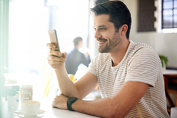 Image showing Happy man, relax at coffee shop with smartphone and scroll online for social media, tech and communication. Chat, reading on app or ebook with break at cafe, contact and using phone with network