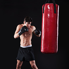 Image showing Man, punch and boxing bag in studio for exercise practice or cardio workout for health, fighter or black background. Male person, gloves and martial arts training on mockup space, performance or fit