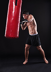 Image showing Man, gloves and boxing bag for exercise practice or cardio workout for health, fighter or black background. Male person, punch and martial arts training in studio on mockup for fitness, gym or fist