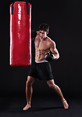 Image showing Man, gloves and boxing bag for fitness practice or cardio workout for health, fighter or black background. Male person, punch and martial arts training in studio on mockup for muscle, gym or fist