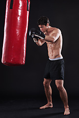 Image showing Man, gloves and boxing bag for workout practice or cardio exercise for health, fighter or black background. Male person, punch and martial arts training in studio on mockup for muscle, gym or strong