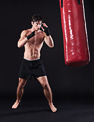 Image showing Man, punching bag and martial arts with fitness, endurance and fighter with challenge and wellness with cardio. Boxer, practice and athlete with exercise and workout with health, sports and progress