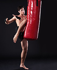 Image showing Kickboxing, bag and man with training, fitness and exercise on a dark studio background. Healthy person, mockup space and model with endurance and practice with workout and wellness with challenge