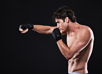 Image showing Fitness, mma and man punching in studio for exercise, challenge or competition training for boxing. Power, muscle or profile of champion boxer at workout with confidence, fight and black background