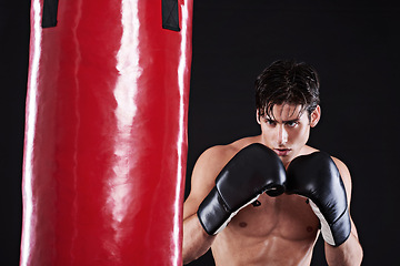 Image showing Fitness, boxing or man with punching bag in studio for exercise, challenge or competition training. Power, muscle or champion boxer at workout with confidence, martial arts fight and black background