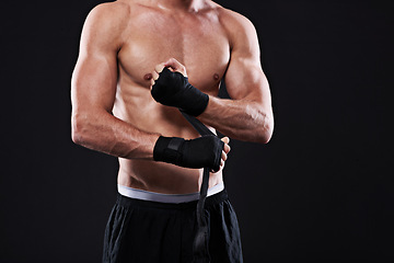 Image showing Wrapping, hands and man in martial arts for boxing on black background in studio with preparation closeup. Tape, fist and ready to start training as boxer in mma or gym with fitness and mockup space