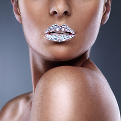 Image showing Beauty, teeth and woman with diamond on lips in studio isolated on a grey background. Face, mouth and sparkle of model with creative makeup for skincare, cosmetics and art for aesthetic with crystal