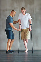 Image showing Man, amputee and crutches in physical therapy with personal trainer for rehabilitation and recovery. Male person with disability, exercise and fitness growth for health, vitality and strength