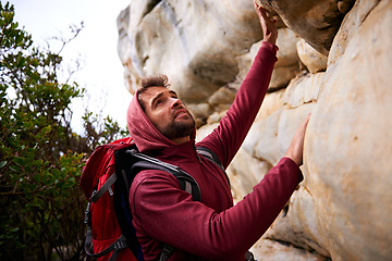 Image showing Man, hiking and climbing mountain with backpack on for fitness, health and adventure. Person, outdoors or in nature looks up at terrain for workout, training and healthy activity or exercise