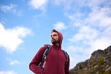 Image showing Blue sky, hiking and man on mountain, thinking and outdoor in nature for adventure, peace and travel. Contemplation, calm and male person in vacation, thoughtful and journey for holiday and backpack