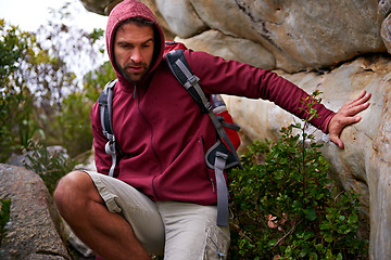 Image showing Cave, rock climbing and man hiking in mountain with backpack for adventure for wellness in trip. Earth, fitness and male person in environment to relax, peace and gear on hill or cliff and land