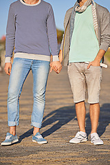 Image showing Holding hands, couple and clothes for fashion on road, location and city of Cape Town for love. Gay, person and partner with pride for relationship on date, sunshine and summer to relax and aesthetic