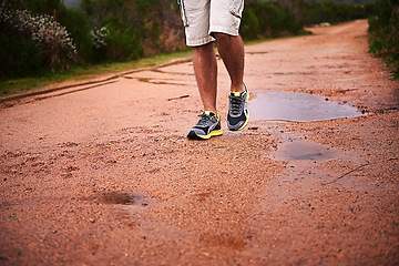 Image showing Legs, shoes and walking on ground in nature, fitness and trekking or hiking, wellness and closeup. Road, training and exercise or workout in park, sports and travel for peace, journey and outdoor