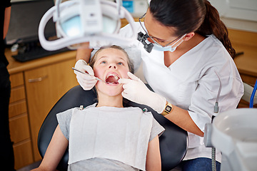 Image showing Female dentist, cavity and child for checkup with teeth examination for mouth hygiene with specialist in healthcare. Professional, orthodontist and equipment with oral treatment at clinic for health