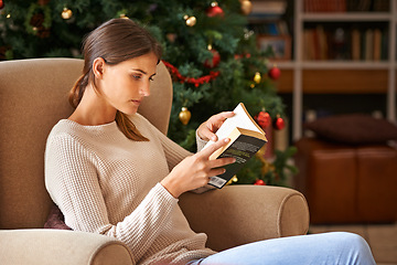 Image showing Woman, reading and book on sofa at christmas in home on vacation. Comfortable, female person and fantasy novel for learning or education in living room during festive holiday with decoration