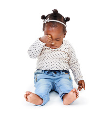 Image showing Child, tired and rubbing eyes in studio while sleepy from playing, learning and motor development in white background. Baby girl or infant, sitting and drowsy or sleeping for nap time, rest and peace