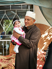 Image showing Muslim, family and grandfather with baby for bonding, Eid celebration or Ramadan with old man and little girl at home. Love, care and support with people from Malaysia for event and Islamic holiday