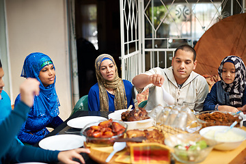 Image showing Family, muslim and home in dinner for eid or ramadan on table for religion to enjoy and satisfied. Faith, Islam and feast in supper from fasting on religious outfit for meal and bonding together