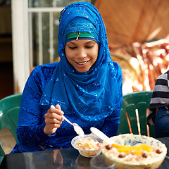 Image showing Woman, muslim and table with dessert for ramadan or eid for religious holiday, celebration and happiness. Islam, traditional and female person with hijab for festival, culture and food for fasting