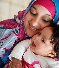 Image showing Happy, muslim and mom with baby in home with love and care for family in Saudi Arabia. Infant, child and Arabic mother relax in house with support and kindness for kid in embrace or hug with mama