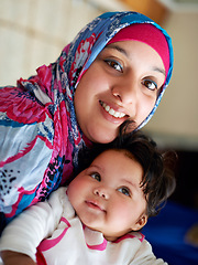 Image showing Happy, baby and portrait of muslim mom in home with love and care for family in Saudi Arabia. Infant, child and Arabic mother relax in house with support and kindness for kid in embrace of mama