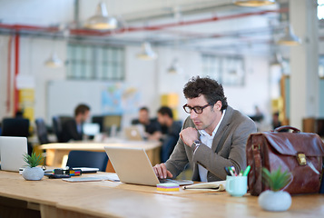 Image showing Laptop, employee and man typing with glasses for sales in startup, business and corporate company. Workplace, bookkeeper and male person working with technology, online and internet in office