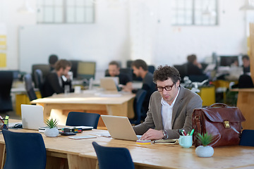 Image showing Laptop, bookkeeper and man typing for sales in startup of business and corporate company. Workplace, staff and male person working with technology, online and internet in office with glasses