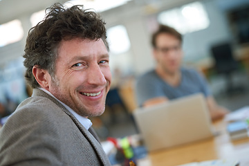 Image showing Happy, portrait and creative man coworking in office with team and planning project with laptop on desk. Mature, employee and productivity in collaboration, cooperation or development of ideas