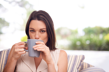 Image showing Woman, home and sofa with drinking coffee to relax or chill on break, day off and enjoy. Portrait, female person and happy in living room on couch with cup of tea for peace and calm in lounge.