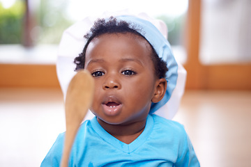 Image showing Baby, hat and wooden spoon in house on floor for child development, growth and motor skills. Black kids, toque and cooking utensil in home in living room for fun, playing and cognitive ability