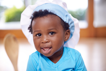 Image showing Black baby, portrait and chef hat in house with spoon, blue tshirt and jeans for child development, learning and cognitive skill. African child, smile and toque in home with clothes for growth